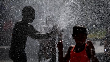 Children play in a fountain at the Andre Citroen park on a sunny and warm summer day as heatwave hits France, in Paris, France, August 12, 2025. REUTERS/Stephanie Lecocq