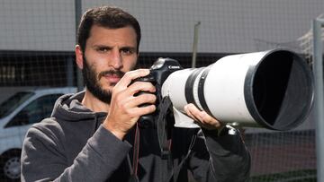 Yacine Qasmi posa para AS sosteniendo una cámara de fotos.