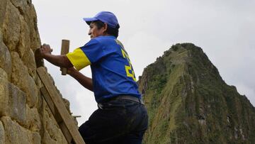 Maintenance staff in the Inca citadel of Machu Picchu, Peru, work on the ancient rock structure that deteriorates constantly due to weather conditions on December 30, 2014. - Authorities announced on June 5, 2020 that health protocols will be implemented in order to reopen in July Perux92s most visited tourist site, which has been closed for three months due to the Covid-19 coronavirus pandemic. (Photo by Cris BOURONCLE / AFP)