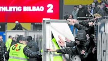 <b>VIOLENTOS. </b>Los agentes de seguridad del estadio vienés intentan impedir la salida al terreno de juego de hinchas violentos e incontrolados.
