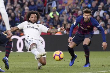 Real Madrid's Brazilian defender Marcelo (L) vies with Barcelona's Spanish defender Gerard Pique during the Spanish league football match between FC Barcelona and Real Madrid CF at the Camp Nou stadium in Barcelona on October 28, 2018. 