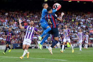 Jordi Masip del Real Valladolid atrapa el balón bajo la presión de Ronald Araujo de Barcelona.