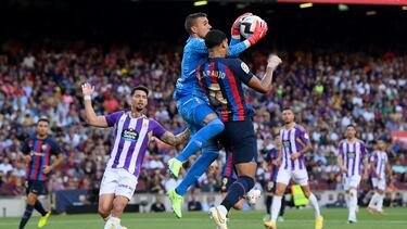Jordi Masip del Real Valladolid atrapa el balón bajo la presión de Ronald Araujo de Barcelona.