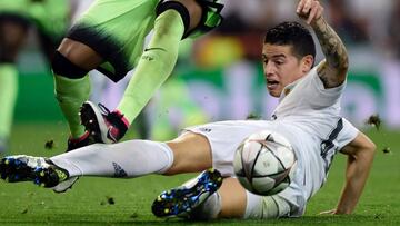 Real Madrid's Colombian midfielder James Rodriguez tackles Manchester City's Brazilian midfielder Fernandinho (L) during the UEFA Champions League semi-final second leg football match Real Madrid CF vs Manchester City FC at the Santiago Bernabeu stadium in Madrid, on May 4, 2016. / AFP PHOTO / JAVIER SORIANO