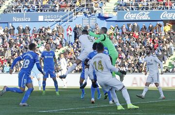 El jugador del Real Madrid, Varane, y el portero del Getafe, Soria, saltan hacia el balón en la jugada del 0-1.