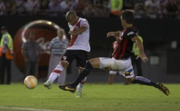 El jugador de River Plate Carlos Sánchez (i) patea y convierte un gol junto a la marca de Matias Caruzzo de San Lorenzo en el partido de ida de la final de la Recopa Sudamericana.