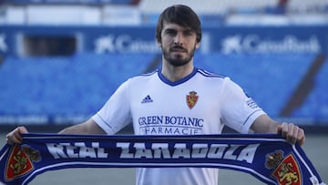 Eugeni Valderrama posa con una bufanda del Real Zaragoza en su presentaci&oacute;n en La Romareda.