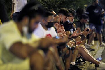 Hinchas enganchados al teléfono y a la espera de noticias durante la noche en Barcelona. 