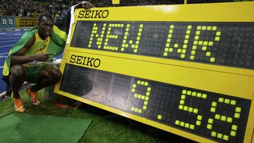 Usain Bolt posa con la marca de su r&eacute;cord mundial de los 100 metros lisos en los Mundiales de Berl&iacute;n 2009.