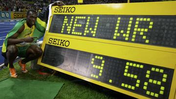 Usain Bolt posa con la marca de su récord mundial de los 100 metros lisos en los Mundiales de Berlín 2009.