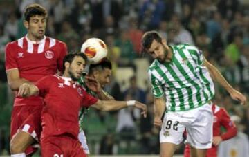 Los defensas argentinos del Sevilla Federico Fazio (i) y Nicolas Pareja disputan un balón aéreo con el delantero brasileño del Real Betis Leo Baptistao, durante el partido correspondiente a la vuelta de octavos de final de Europa League, disputado hoy en el estadio Benito Villamarín.