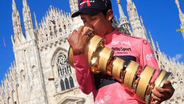 TOPSHOT - Team Ineos rider Colombia's Egan Bernal kisses the race's Trofeo Senza Fine (Endless Trophy) on the podium after winning the Giro d'Italia 2021 cycling race following the 21st and last stage on May 30, 2021 in Milan. (Photo by Luca Bettini / AFP