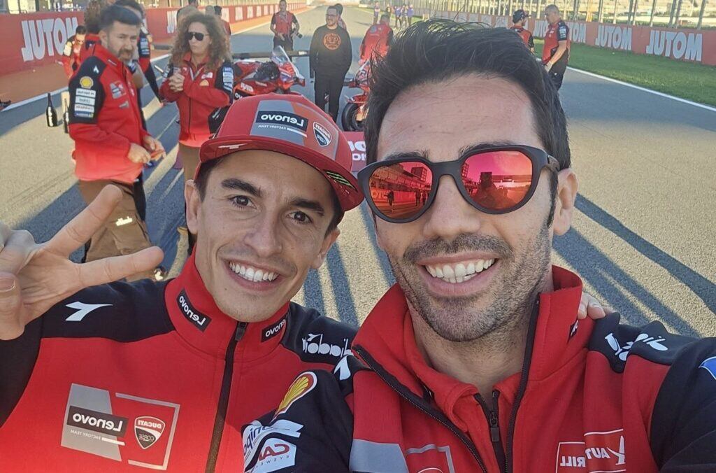 Michelle Pirro, probador de Ducati, posa con Marc Márquez en la parrilla de salida de Valencia.