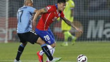 Aránguiz recibe la marca de Arévalo en el duelo contra Uruguay.