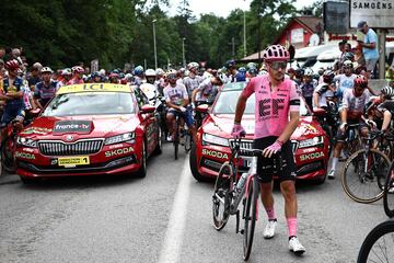 Ciclistas del pelot¨®n espectantes tras la detenci¨®n de la carrera debido al accidente masivo en el que cayeron al suelo m¨¢s de 30 ciclistas.
