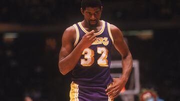 <b>- Años en la NBA:</b> 1979-1996 <br> <b>- Equipos:</b> Los Angeles Lakers <b>- Medias de su carrera:</b> 19,5 puntos, 7,2 rebotes, 11,2 asistencias <br> <b>- Mejor temporada:</b> (1986-87) 23,9 puntos, 6,3 rebotes, 12,2 asistencias. <br> <b>- Méritos:</b> 5 veces campeón, 3 veces MVP, 3 veces MVP de las finales, 12 veces All Star, 9 veces en el mejor quinteto. <br> <br> Ni siquiera hay debate. Magic cambió el baloncesto: un base que medía 2,06, enorme para cualquier rival de su época, rápido de piernas y todavía más de pensamiento, con una visión de juego superdotada y un estilo que enamoró al público, hermanó a los Lakers con Hollywood y gobernó la NBA de los ochenta. Magic: pura magia.