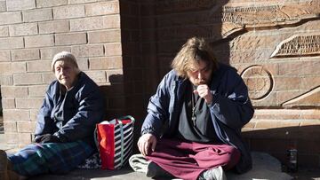 SEATTLE, WA - APRIL 06: James Deane (R) has a bad cough but he and friend Marla (no last name given) say they feel alright as they sit on the sidewalk on April 6, 2020 in Seattle, Washington. Both of them are staying at a nearby shelter where they say the