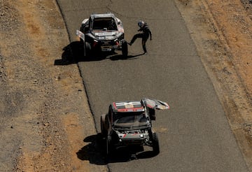 Pau Navarro y Lisandro Sisterna del equipo BBR y Sebastien Loeb y Fabian Lurquin del Dacia Sandriders, se encuentran parados durante la tercera etapa por problemas mecánicos.