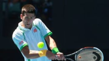 El serbio Novak Djokovic golpea un revés en su debut en el Abierto de Australia frente al francés Paul-Henri Mathieu.