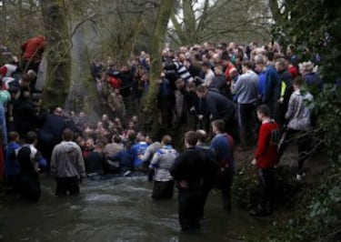 Players stand in a river as they compete for the ball during the annual Shrovetide football match in Ashbourne, Britain February 28, 2017. The aim of the teams, the Up'ards and the Down'ards, is to score by tapping the ball three times on stone goal plinths three miles apart on the banks of the River Henmore. The game dates back to the 17th century. REUTERS/Phil Noble