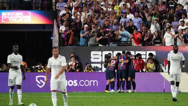 Los jugadores del Barcelona celebran el gol de Raphinha ante los desolados madridistas.