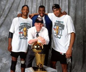 Sean Elliot, David Robinson, Tim Duncan y Greg Poppovich posan con el trofeo de campeón de la NBA.