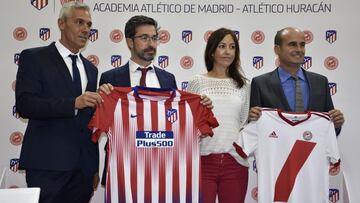 Emilio Guti&eacute;rrez, director de la Academia del Atl&eacute;tico, posa sosteniendo uma camiseta del equipo madrile&ntilde;o durante un acto con el Atl&eacute;tico Hurac&aacute;n.