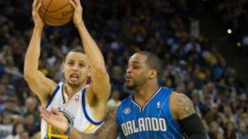 Stephen Curry (30) trata de marcharse de Jameer Nelson (14).