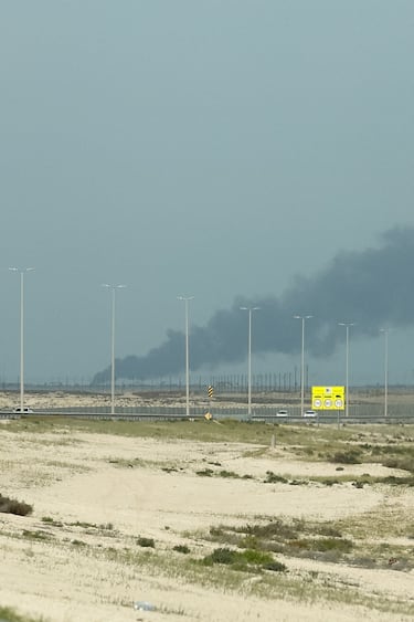 Los vehículos circulan por una carretera mientras se elevan columnas de humo desde la refinería de petróleo Ras Tanura.