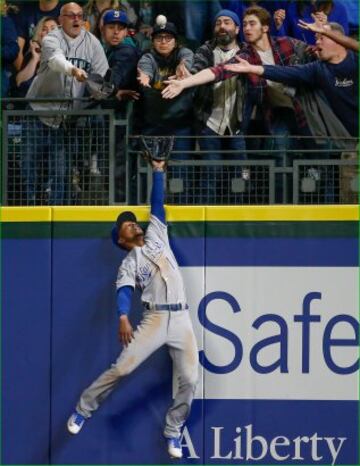 El jugador de los Kansas City Royals Harrod Dyson est¨¢ preparado para coger la bola de b¨¦isbol del equipo rival, Seattle Mariners, aunque le ha salido competencia. Hasta cuatro espectadores ponen su mano para cogerla, aunque hay un quinto aficionado, el m¨¢s avezado, que pone la gorra para cazarla. Esa pelota no llega al suelo, eso seguro.