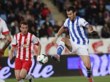 El delantero de la Real Sociedad, Aguirretxe (d), intenta controlar el balón ante el jugador del Almeria, Mané, durante el encuentro que disputan esta noche en el estadio de los Juegos del Mediterraneos en Almeria.