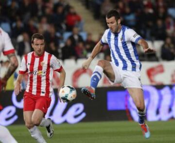 El delantero de la Real Sociedad, Aguirretxe (d), intenta controlar el balón ante el jugador del Almeria, Mané, durante el encuentro que disputan esta noche en el estadio de los Juegos del Mediterraneos en Almeria.