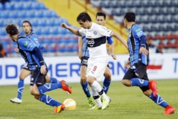 Sebastián Silva cubre el balón ante la marca de los jugadores de Huachipato.