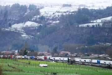 Varios camiones parados en la A-67 en Cantabria. Desde primera hora, la A-67 se encuentra en nivel rojo por la nieve con la circulación prohibida para camiones, autobuses y vehículos articulados, y la obligatoriedad de cadenas o neumáticos de invierno y una velocidad máxima de 30 kilómetros por hora para el resto de vehículos entre los kilómetros 117 y 157.