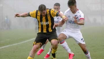 JJPANA3220. MONTEVIDEO (URUGUAY), 09/08/2020.- Mathias Laborda (d) de Nacional disputa un bal&oacute;n con Cristian Rodr&iacute;guez de Pe&ntilde;arol en un partido de la cuarta fecha del Torneo Apertura entre Club Nacional y Pe&ntilde;arol hoy, en el est