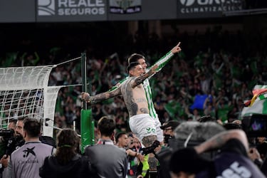 Los jugadores y aficionados del Betis, celebran la victoria ante el Sevilla tras finalizar el partido en el estadio Benito Villamarín.