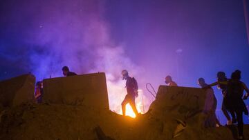 BEIRUT, LEBANON - AUGUST 09: Protestors make their way past a fire lit by an Internal Security Forces tear gas canister during a protest near Martyrs Square on August 9, 2020 in Beirut, Lebanon. Large protests continued for a second day as the Lebanese ca