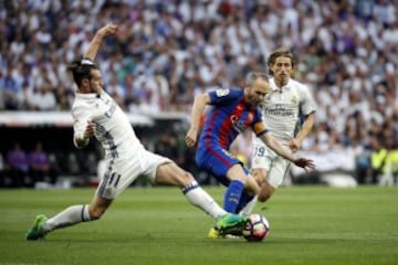 El centrocampista del Barcelona Andrés Iniesta pelea un balón con el centrocampista galés del Real Madrid, Gareth Bale 