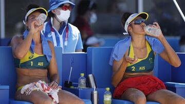 Juegos Olímpicos de Tokio 2020 - Voleibol de playa - Mujeres - Grupo E - Australia (Artacho del Solar / Clancy) v Cuba (Lidy / Leila) - Parque Shiokaze, Tokio, Japón - 25 de julio de 2021. Bebida de Mariafe Artacho de Australia y Taliqua Clancy de Australia agua entre los sets. REUTERS / John Sibley