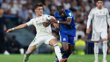 Real Madrid's Turkish midfielder #15 Arda Guler (L) vies for the ball with Marseille's Central midfielder #19 Geoffrey Kondogbia during the UEFA Champions League first round day 1 football match between Real Madrid CF and Olympique de Marseille at the Santiago Bernabeu stadium in Madrid on September 16, 2025. (Photo by Oscar DEL POZO / AFP)