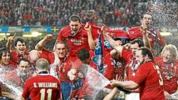<b>FESTEJO DE LOS DRAGONES. </b>Shane Williams, 'El Oso' Jones y Martyn Williams riegan con champagne al resto de sus compañeros en la celebración del Grand Slam.