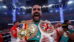 Tyson Fury celebrates with the belts