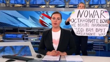 This video grab taken on March 15, 2022 shows Russian Channel One editor Marina Ovsyannikova holds a poster reading " Stop the war. Don't believe the propaganda. Here they are lying to you" during on-air TV studio by news anchor Yekaterina Andreyeva , Russia's most-watched evening news broadcast, in Moscow on March 14, 2022 . - As a news anchor Yekaterina Andreyeva launched into an item about relations with Belarus, Marina Ovsyannikova, who wore a dark formal suit, burst into view, holding up a hand-written poster saying "No War" in English. (Photo by Handout / AFP) / RESTRICTED TO EDITORIAL USE - MANDATORY CREDIT "AFP PHOTO / Channnel One - NO MARKETING NO ADVERTISING CAMPAIGNS - DISTRIBUTED AS A SERVICE TO CLIENTS