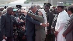 FILE PHOTO: Nelson Mandela (L) is embraced by PLO leader Yasser Arafat as he arrives at Lusaka airport February 27, 1990.  REUTERS/Howard Burditt/File Photo
