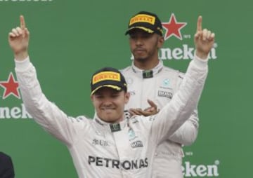 Mercedes driver Nico Rosberg of Germany, left, celebrates as second placed Mercedes driver Lewis Hamilton of Britain applaudes on the podium the Italian Formula One Grand Prix at the Monza racetrack, Italy, Sunday, Sept. 4, 2016