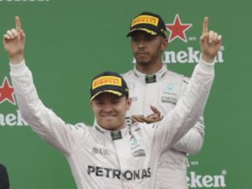 Mercedes driver Nico Rosberg of Germany, left, celebrates as second placed Mercedes driver Lewis Hamilton of Britain applaudes on the podium the Italian Formula One Grand Prix at the Monza racetrack, Italy, Sunday, Sept. 4, 2016