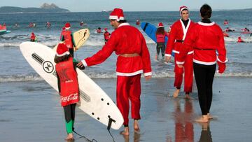 GRAF2021. NIGR&Aacute;N (PONTEVEDRA), 23/12/2018.- Cientos de Pap&aacute;s Noel han llegando este soleado domingo a la playa de Patos, en Nigr&aacute;n (Pontevedra), surfeando sobre sus tablas las olas de este arenal, en una estampa m&aacute;s propia de l