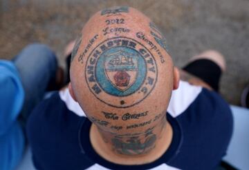 En el Etihad Stadium se pudo ver a un aficionado del Manchester City con un tatuaje que deja pocas dudas sobre cuál es su equipo favorito. En la cabeza tiene diferentes diseños dibujados, pero el escudo central es el que llevaron los citizens desde 1972 hasta 1997 con el eslogan “Campeones de la Premier League 2012”.