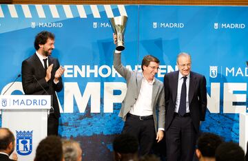 El alcalde de Madrid, José Luis Martínez-Almeida, levanta una réplica de la copa de la Euroliga ante el jugador del Madrid, Sergio Llull y el presidente del club, Florentino Pérez.