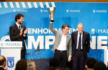 El alcalde de Madrid, José Luis Martínez-Almeida, levanta una réplica de la copa de la Euroliga ante el jugador del Madrid, Sergio Llull y el presidente del club, Florentino Pérez.